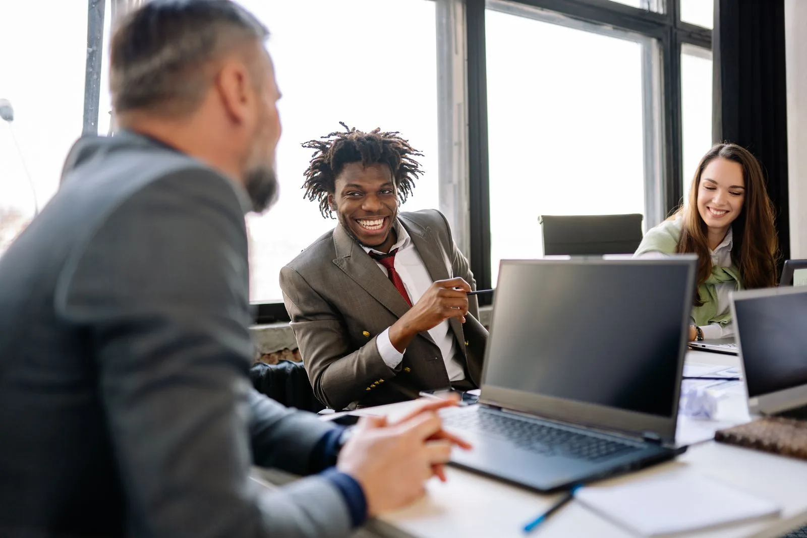 A diverse, energized corporate team collaborating in a bright office after building better workday habits