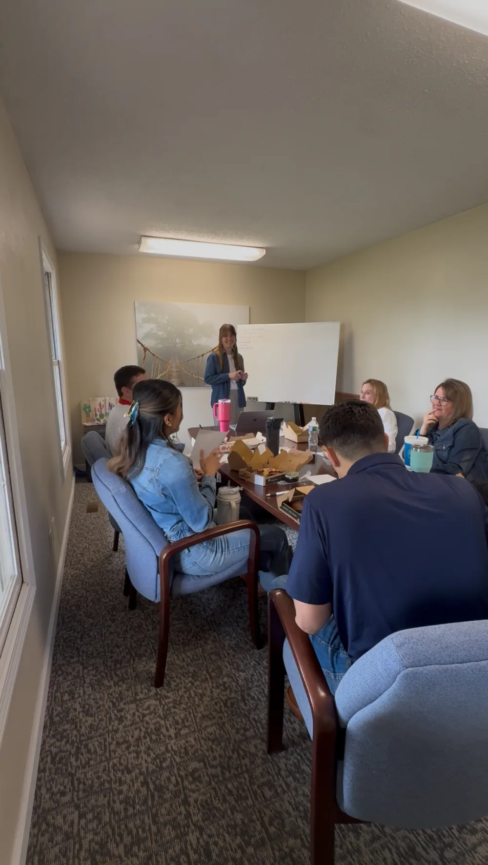 Abigail Parker leading a High Energy Workdays workshop for a seated team over lunch in a conference room